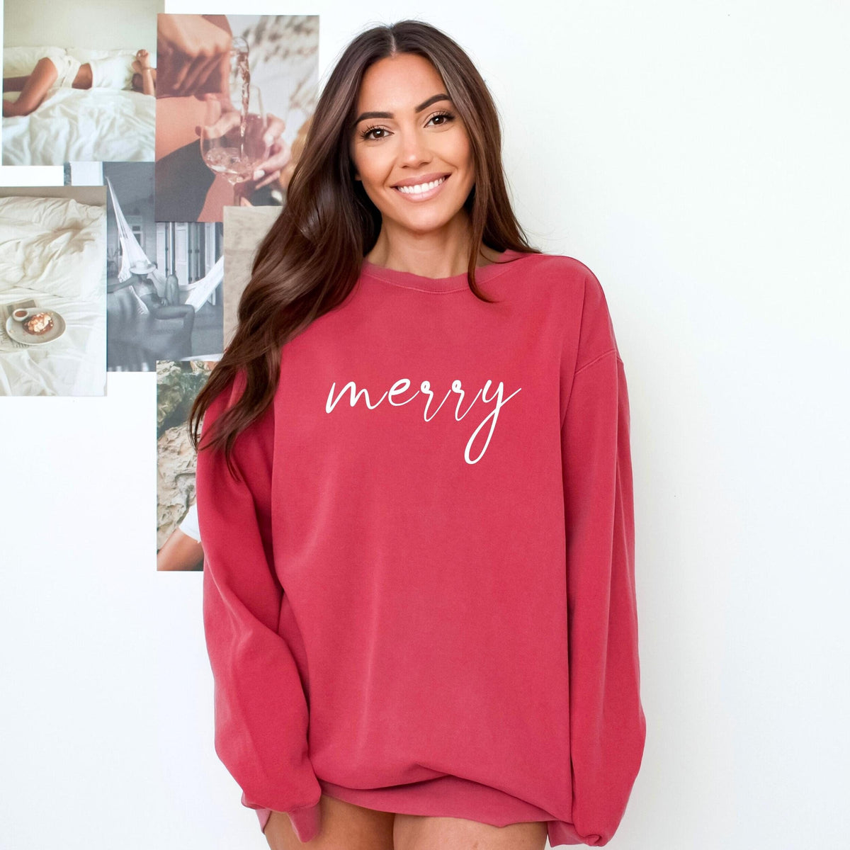 Model wearing a crimson crewneck sweatshirt with merry in white cursive