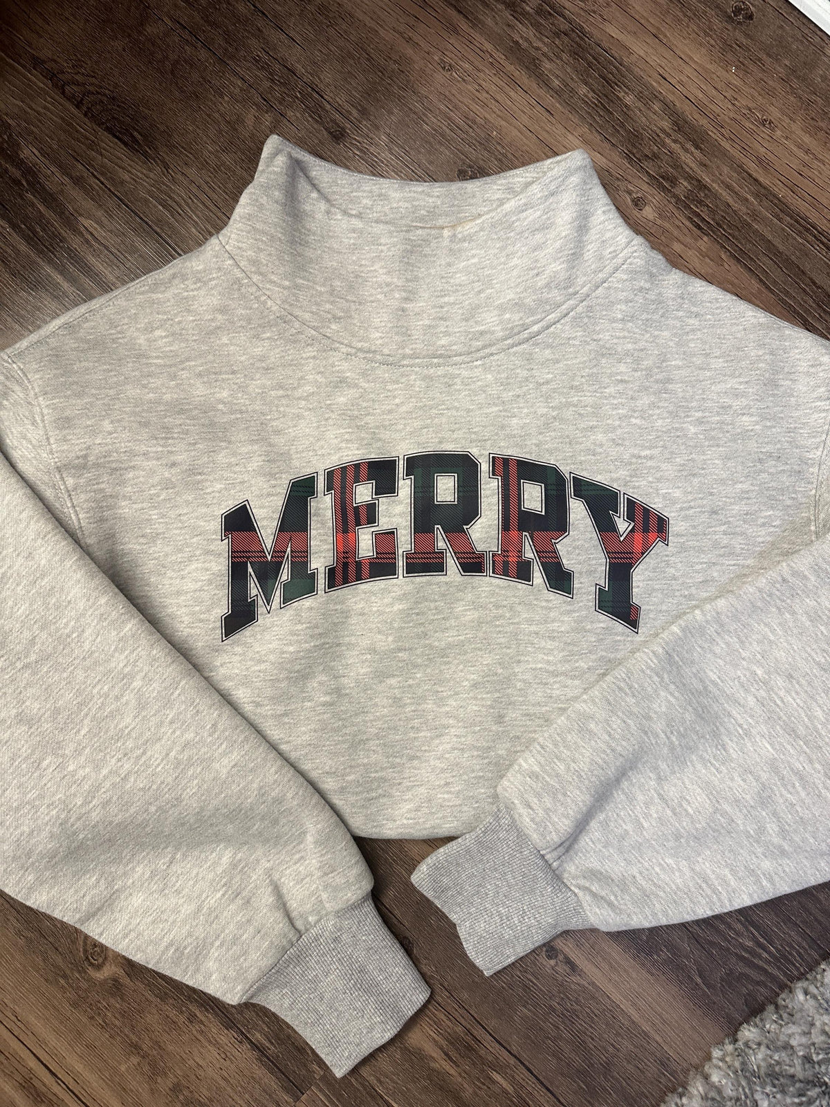 Grey mockneck sweatshirt with MERRY in red and green plaid varsity letters